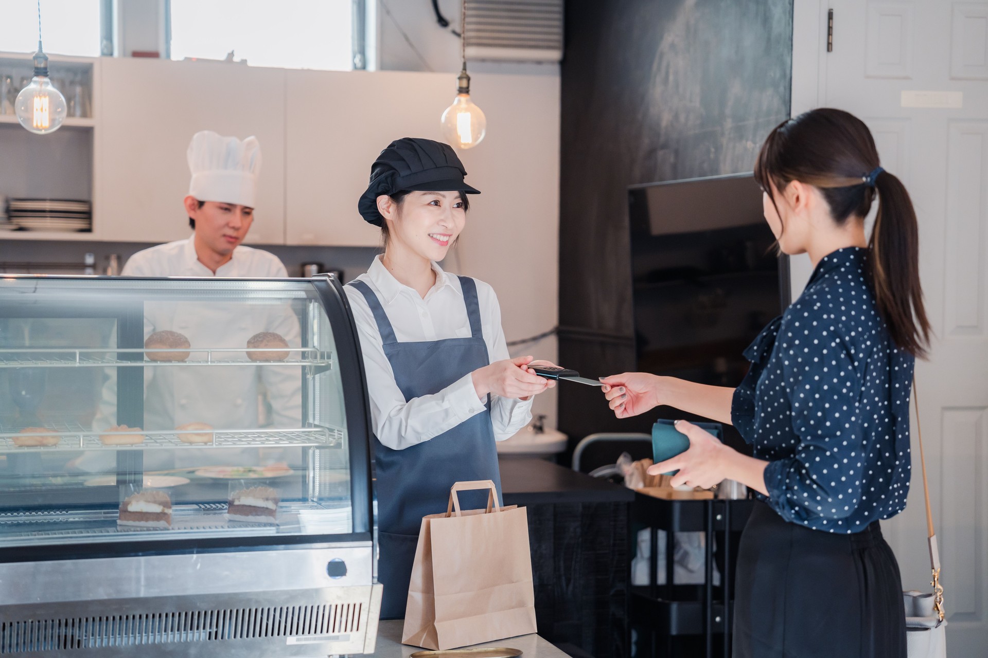 A woman making a credit card payment at a candy shop